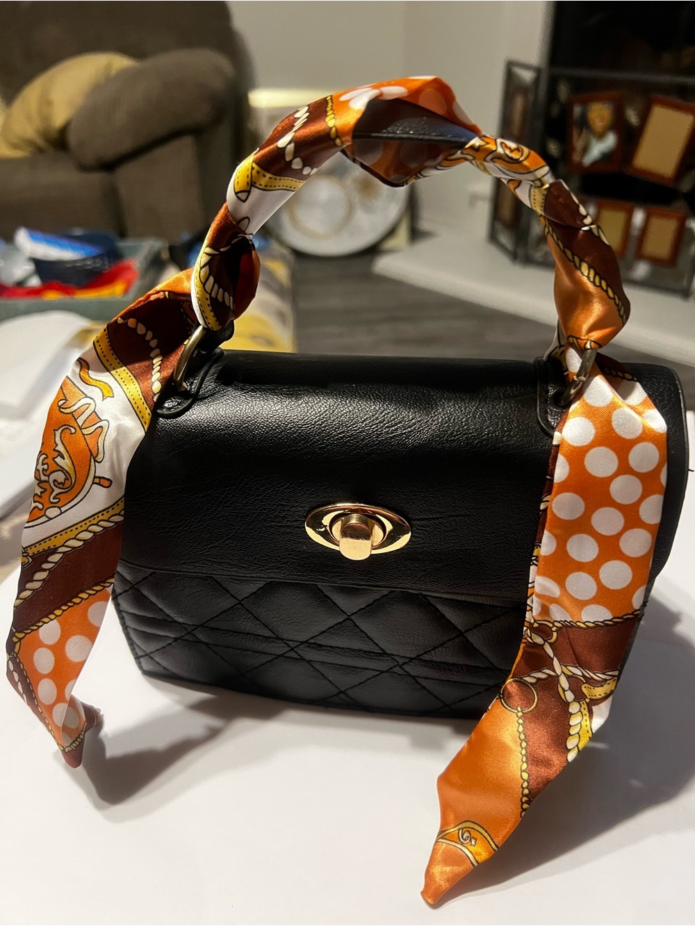 Black Quilted Top-Handle Bag with Orange Scarf Accent